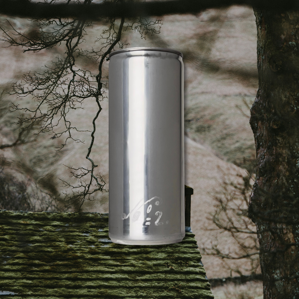 Sloan Rose N°2 Ember & Cream candle in a reclaimed aluminum vessel, resting on a mossy roof beneath bare winter branches.