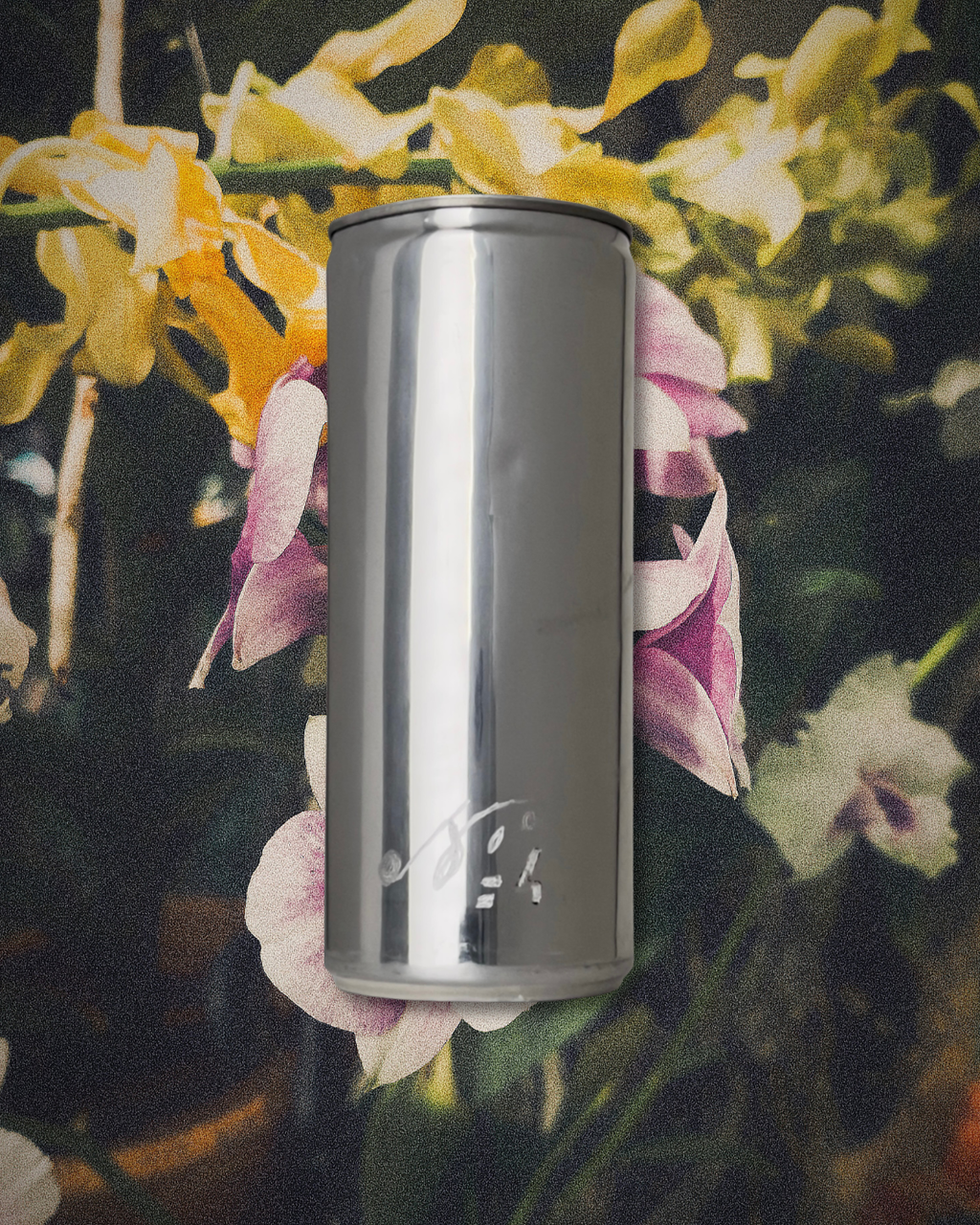 Sloan Rose N°4 Orchid & Summer Storm candle in a reclaimed aluminum vessel, among orchids in dark, storm dimmed light.
